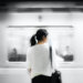woman in white elbow-sleeved shirt standing near white train in subway